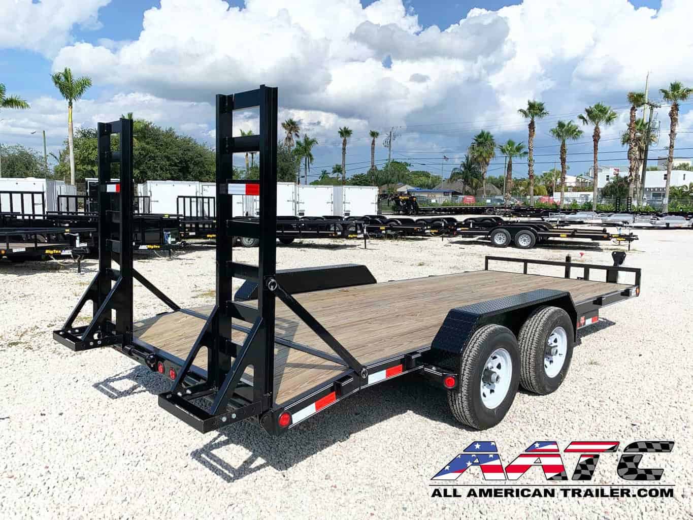 A black PJ 18-foot equipment trailer with a 10,000 GVWR. This PJ Trailer features a straight deck with fold-up ramps, providing a load capacity of 7060 lbs. It is designed for bumper pull hitch type towing and equipped with electric brakes for added safety. The trailer is perfect for hauling various equipment and cargo, and it's from the renowned PJ Trailers brand.