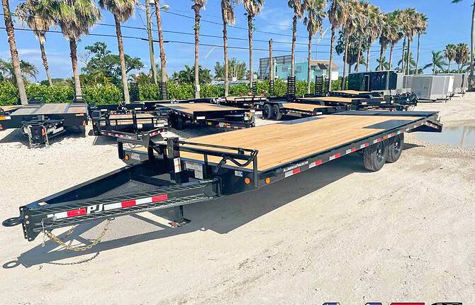 A black PJ 24-foot deckover equipment trailer with an 8-ton capacity and a 16,000 GVWR. This PJ Trailer features Monster Ramps, large LR-G tires, electric brakes, and a bumper pull hitch type. It is designed for heavy-duty hauling and is part of the PJ Trailers lineup