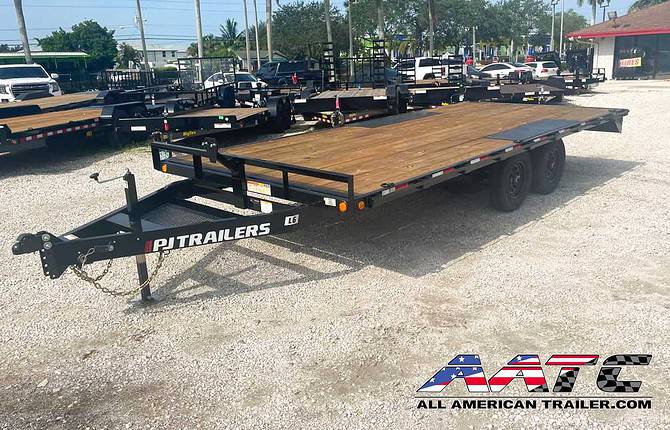 A black PJ 16-foot deckover equipment trailer with a 9,899 GVWR. This PJ Trailer features slide-in ramps, making it easy to load and unload equipment. It is a bumper pull hitch type trailer with electric brakes for enhanced safety. The PJ Deckover Trailer is designed for heavy-duty hauling and is part of the renowned PJ Trailers lineup.