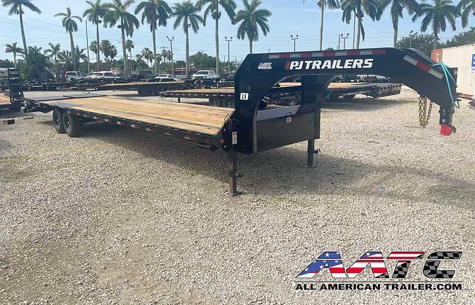 A black 35-foot gooseneck trailer from PJ Trailers, model LS-30+5MR. This heavy-duty gooseneck trailer has an impressive 15,680 GVWR and features electric brakes, radial tires, and dual 12,000-pound drop-leg jacks bolted on. It comes equipped with Lippert brand axles and a lockable toolbox located between the gooseneck uprights. The trailer has a 5-foot dovetail with 5 double-hinged spring-assist flip-over ramps, and it includes the MONSTER Ramps upgrade. Its low-profile bed and pierced-beam frame make it ideal for various heavy-duty hauling tasks.