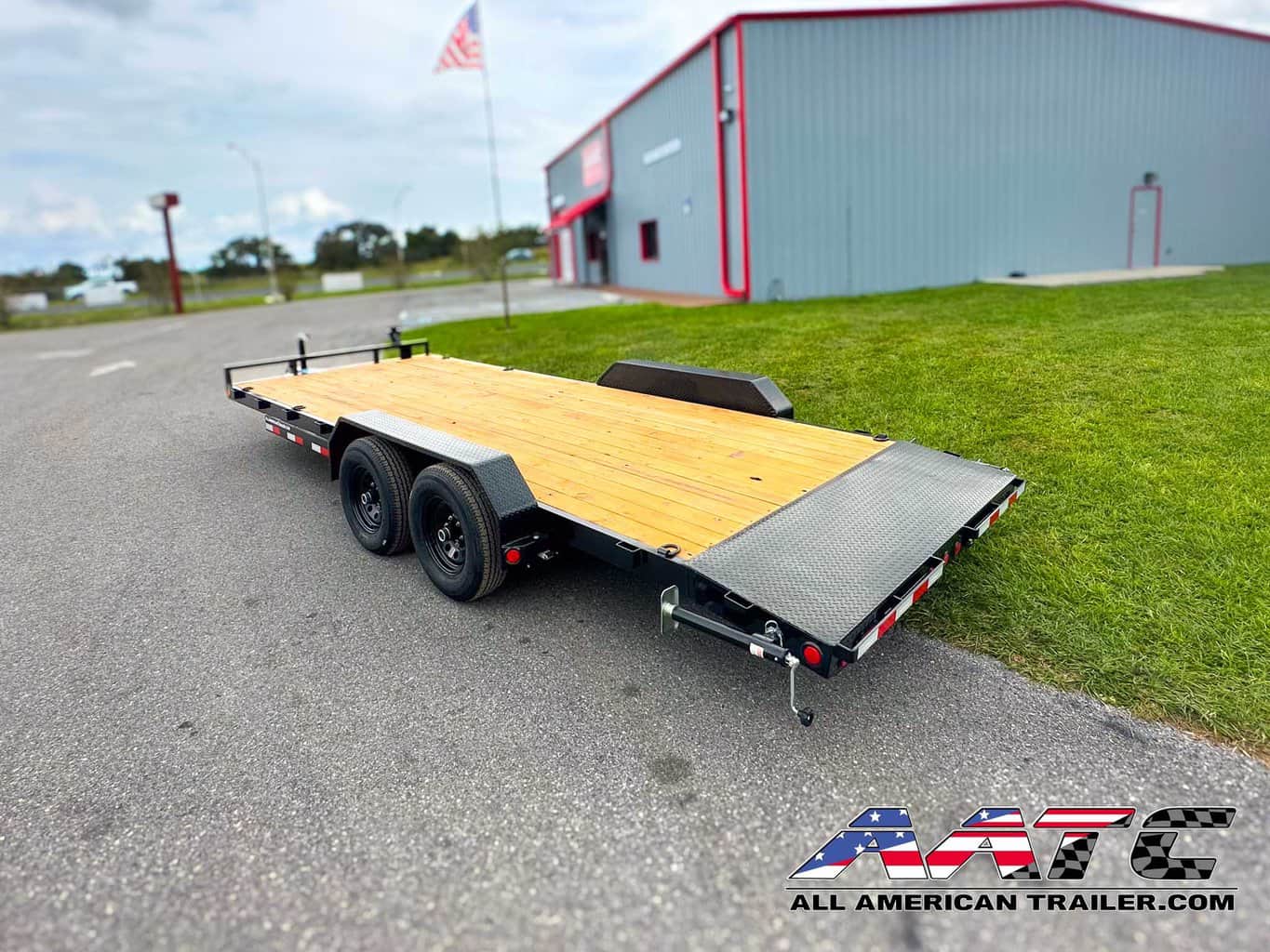 A PJ 20-foot car hauler trailer, model CE-202-SIR, designed for versatile vehicle transportation. This PJ Trailer features a 2-foot dovetail with 5-foot slide-in ramps, making it easy to load and unload vehicles. With a 10,000 GVWR, electric brakes, and a black finish, it's a durable and efficient choice for car hauling with a load capacity of 7500 lbs. The bumper pull design allows for convenient towing