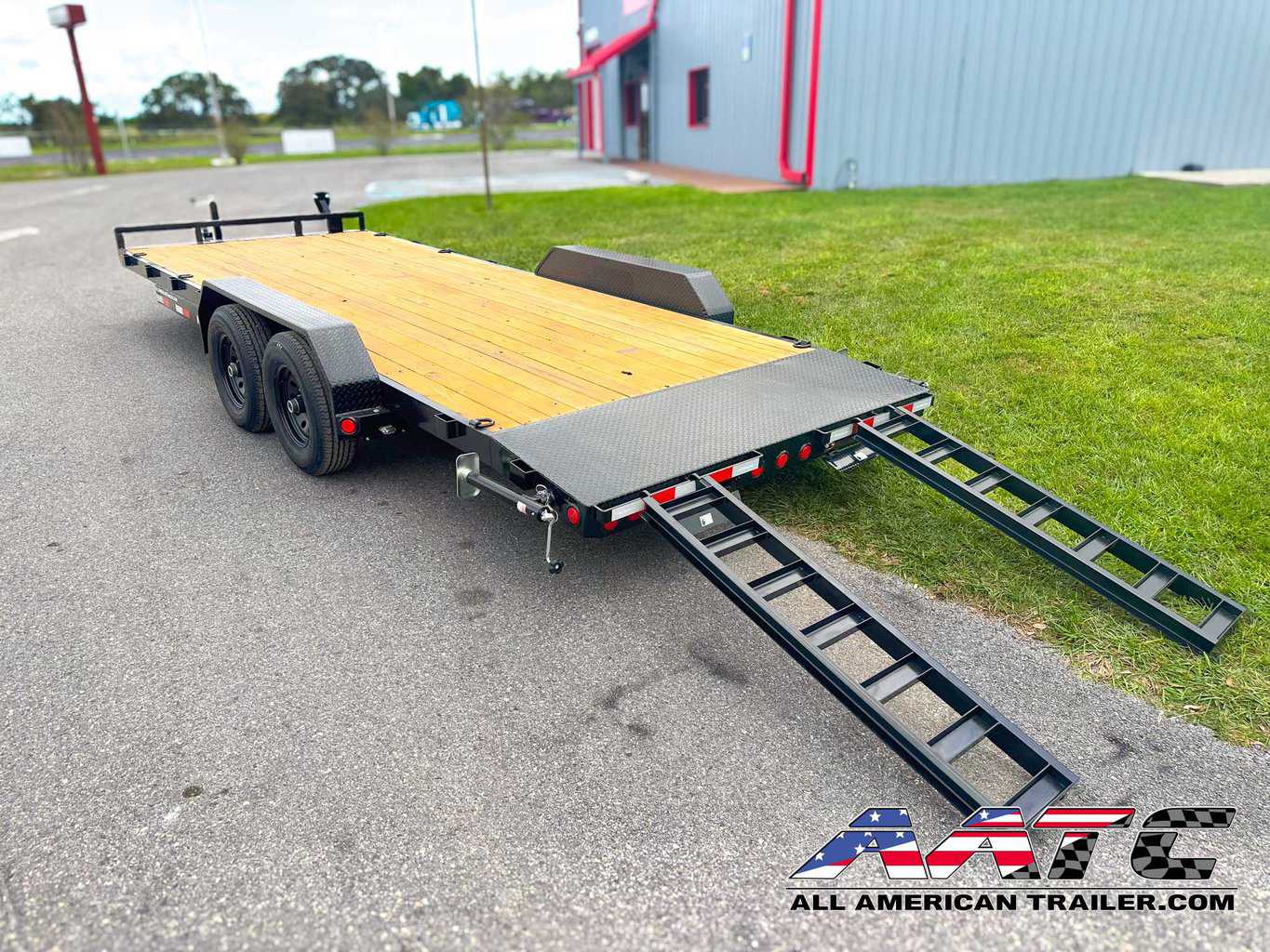 A PJ 20-foot car hauler trailer, model CE-202-SIR, designed for versatile vehicle transportation. This PJ Trailer features a 2-foot dovetail with 5-foot slide-in ramps, making it easy to load and unload vehicles. With a 10,000 GVWR, electric brakes, and a black finish, it's a durable and efficient choice for car hauling with a load capacity of 7500 lbs. The bumper pull design allows for convenient towing
